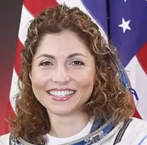 Anousheh Ansari woman with chestnut curly hair against a USA flag